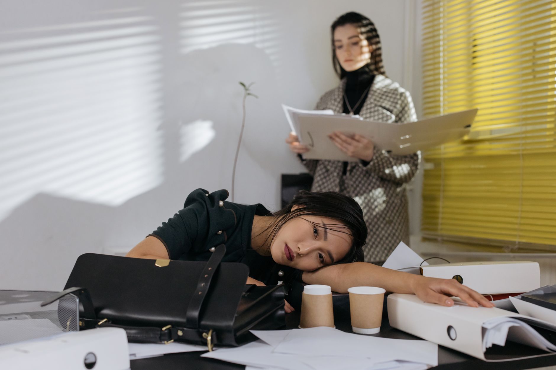 Employé fatigué assis à son bureau dans un open space, illustration des risques psychosociaux au travail